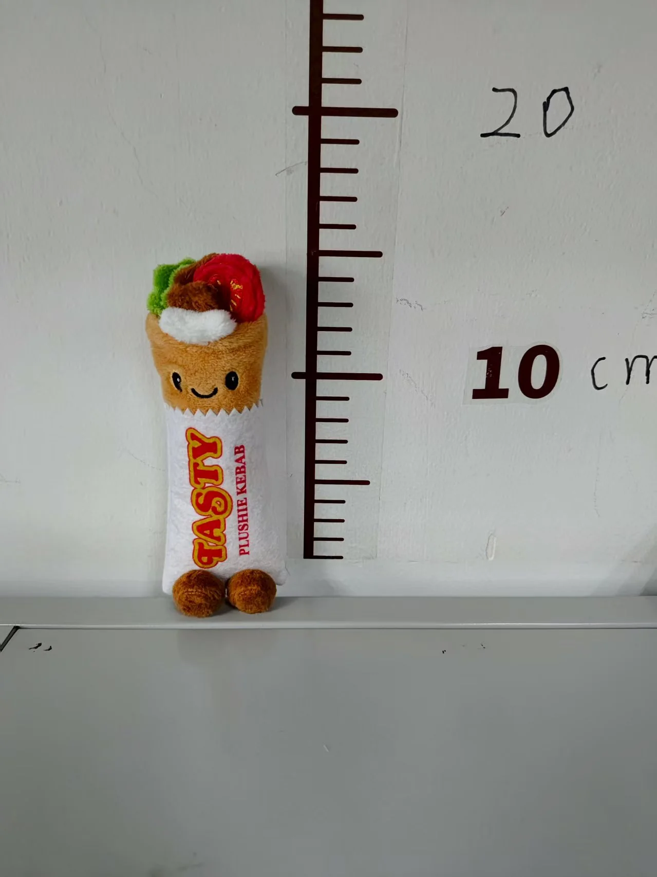 Front view of the smaller kebab-wrap plush sample, showing its face, body graphics and topping details