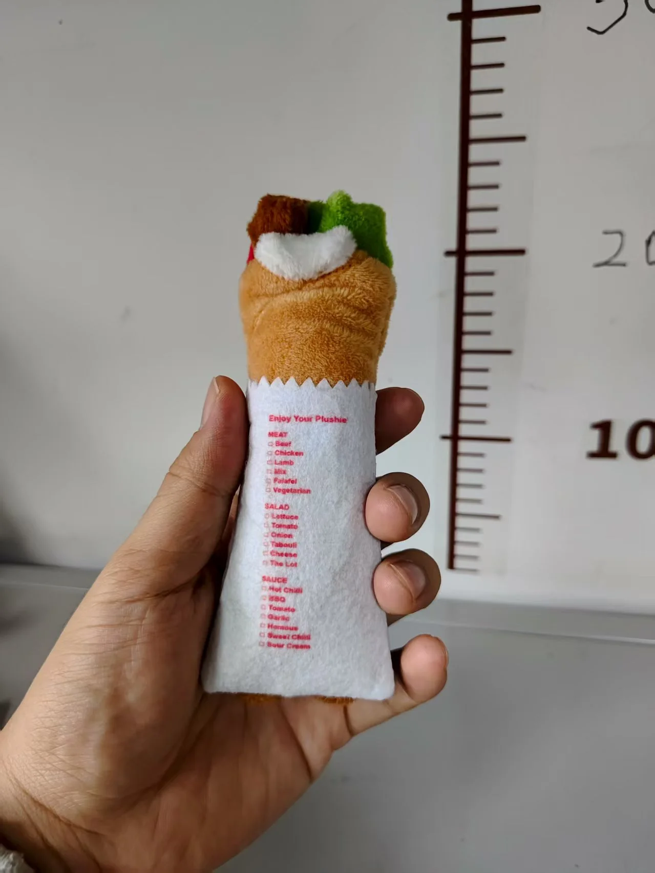 Printed text on the back of the smaller plush sample, with the top components visible
